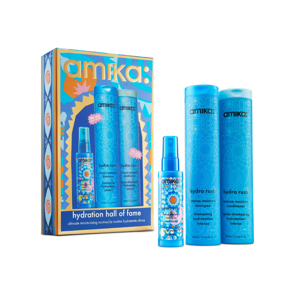 Amika Hair 'Hydration Hall of Fame' gift set featuring a decorative illustrated box and three blue haircare bottles and a spray bottle on a white background.