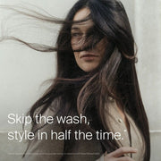 Woman misting Living Proof Style Refresh Mist through hair lengths to refresh between-wash style