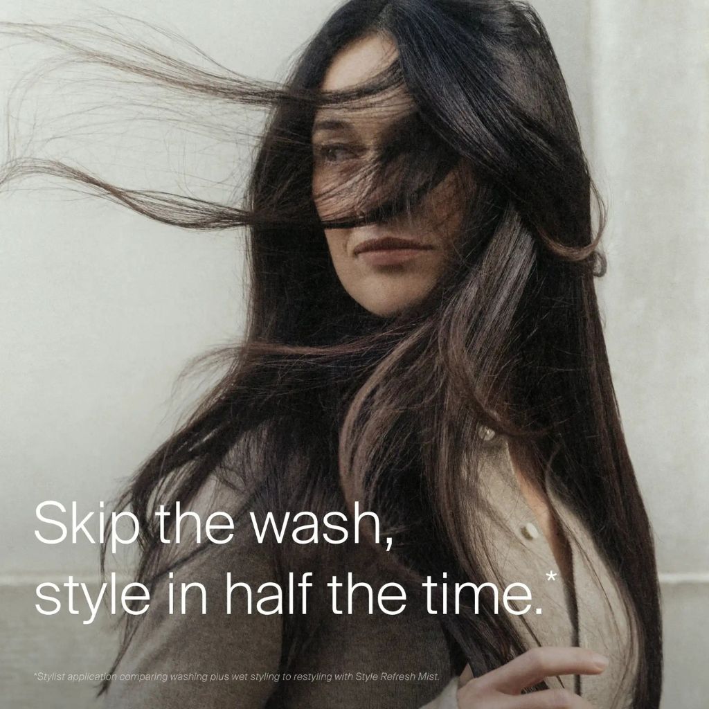 Woman misting Living Proof Style Refresh Mist through hair lengths to refresh between-wash style