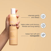 Woman with defined, frizz-free curls using the milk_shake Curl Passion 1L duo set
