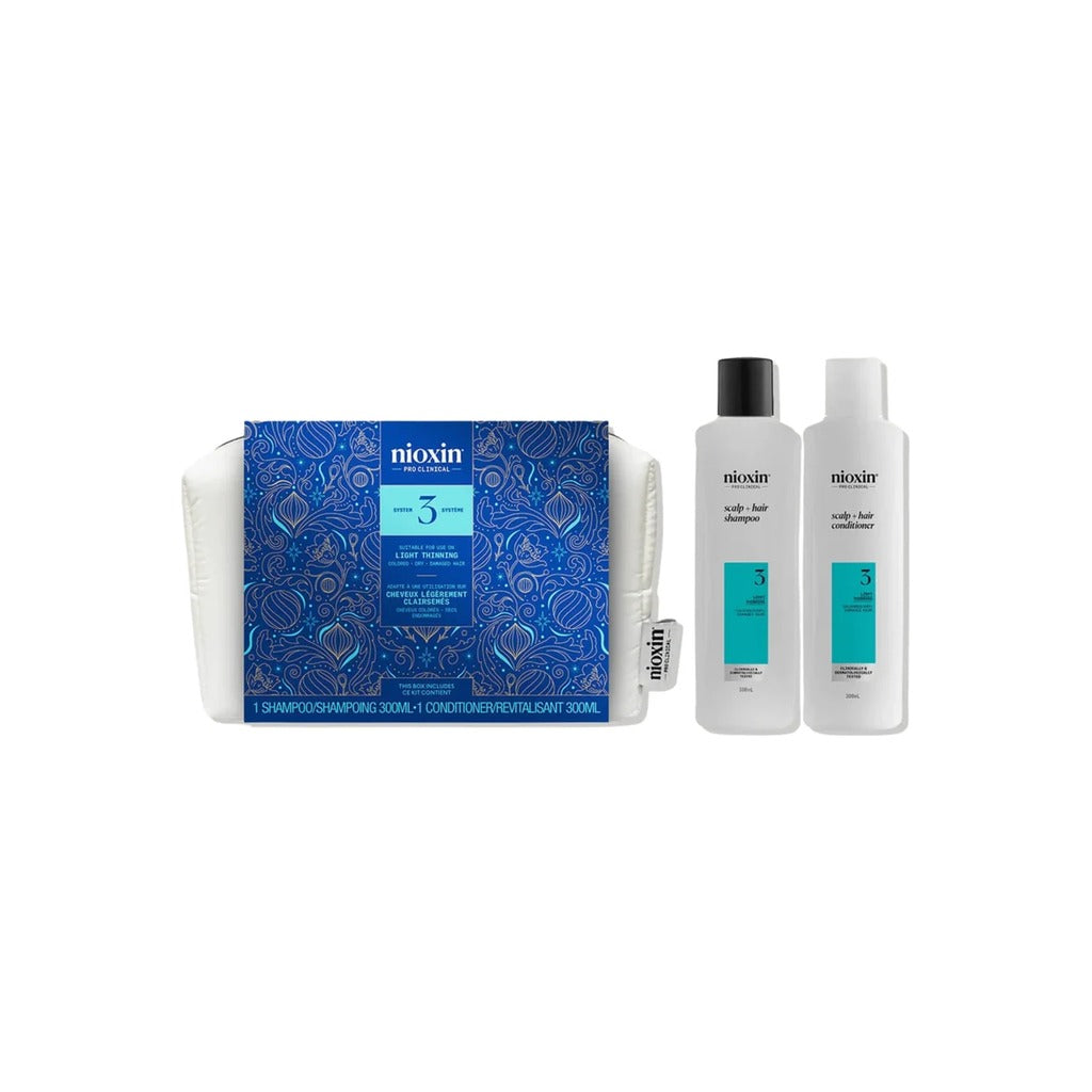 Nioxin System 3 Holiday Set with scalp and hair shampoo and conditioner beside white zip cosmetic bag